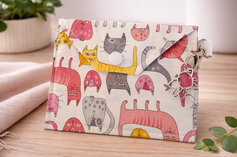 Handmade pink and gray cat-print snap pouch with a silver cat charm